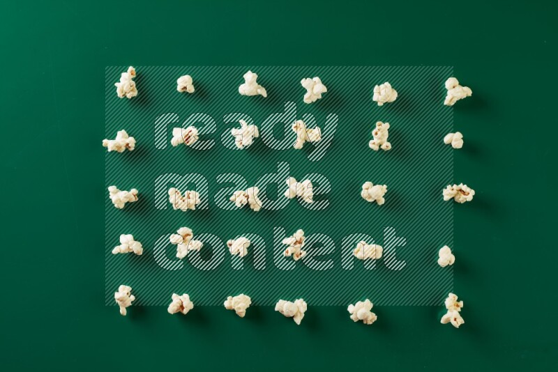 Popcorn flakes on a green background in a top view shot