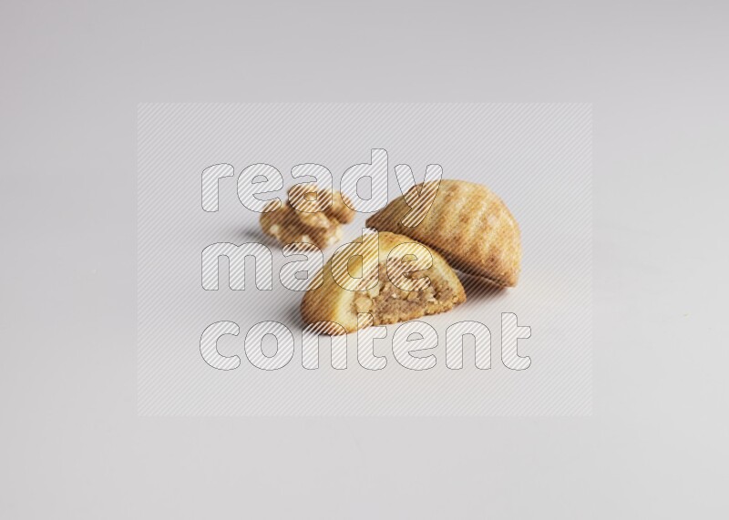 Two Pieces of Maamoul filled with walnut paste  one of them is cut direct on white background