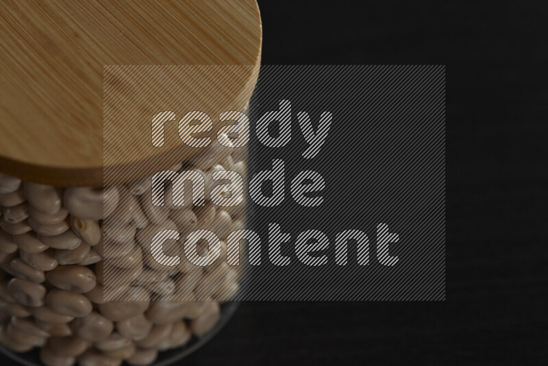 Lupin Beans in a glass jar on black background