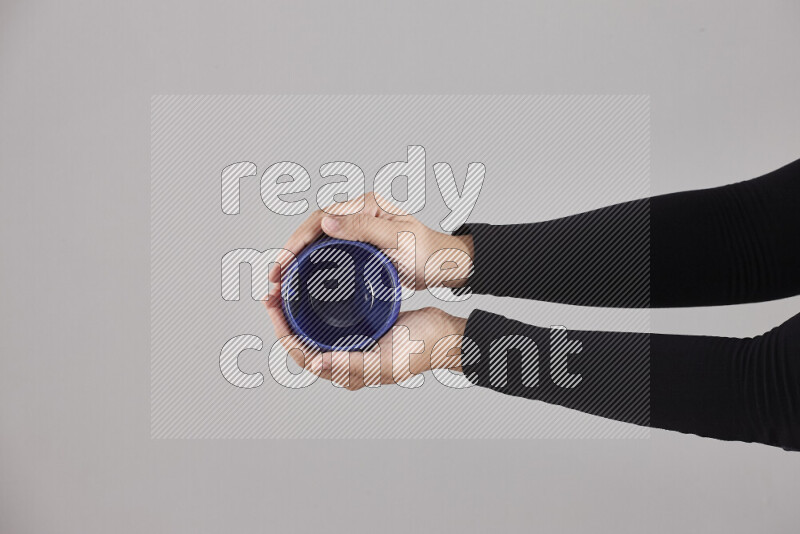 A woman in black abaya holding different pottery essentials in different positions