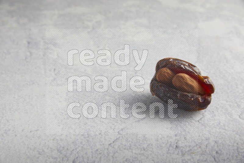 almond stuffed madjoul date on a light grey background
