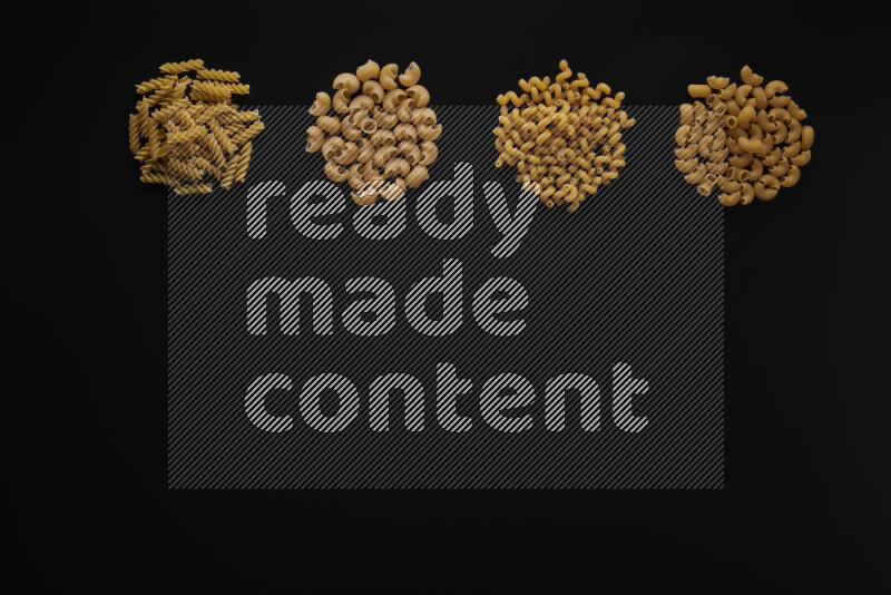 Different pasta types in 4 bunches on black background