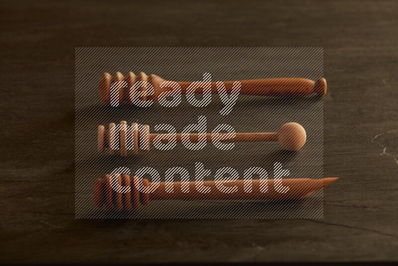 Wooden honey dipper on black slate background