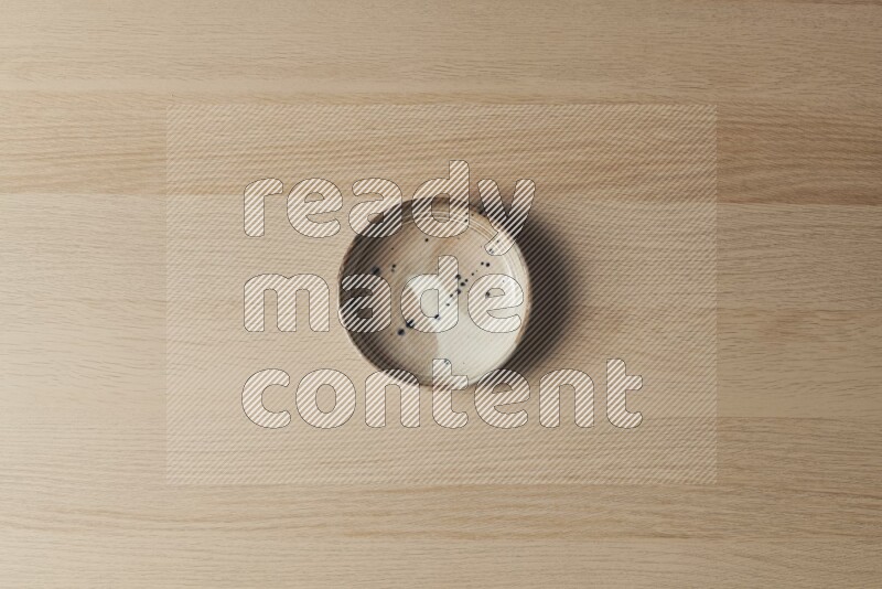 A multicolored pottery plate on light wooden background