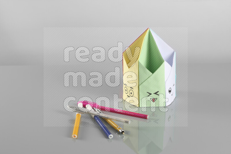 Origami pen holder on grey background