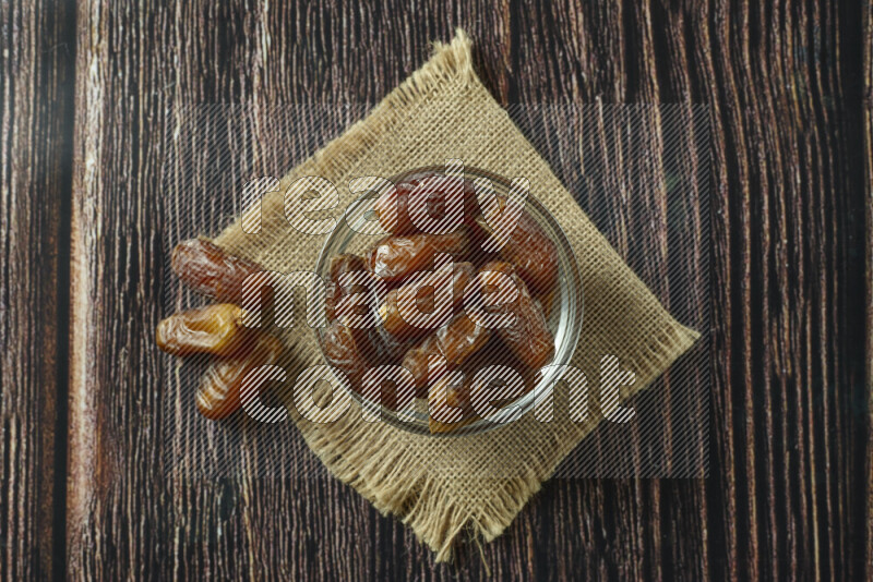 Dates in different bowls (wooden, pottery and glass) on wooden background
