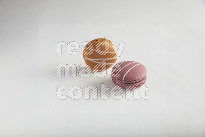 45º Shot of of two assorted Brown Irish Cream, and Red Poppy Flower macarons on white background