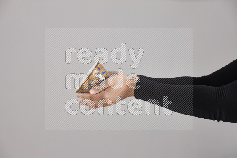 A woman in black abaya holding different pottery essentials in different positions