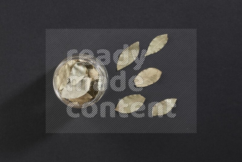 وعاء زجاجي ممتلئ بأوراق الغارعلي خلفية سوداء