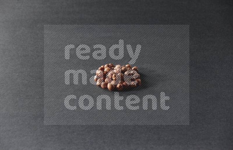 A bunch of peeled hazelnuts on a black background in different angles