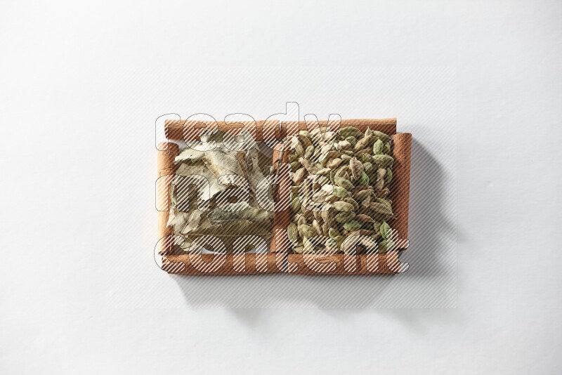 2 squares of cinnamon sticks full of cardamom and bay laurel leaves on white flooring