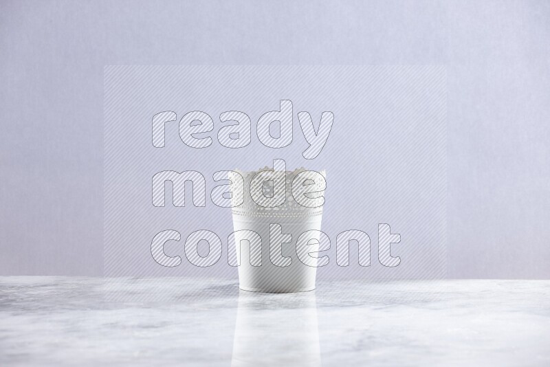 An empty white plant pot on grey marble background