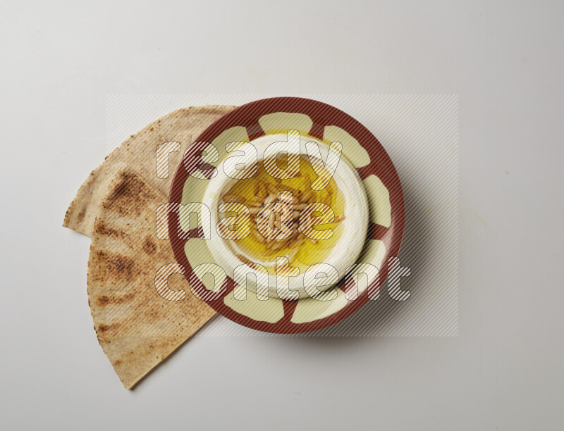 Lebnah garnished with pine nuts in a traditional plate on a white background