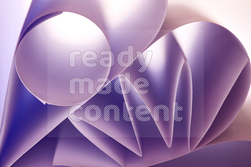 An artistic display of paper folds creating a harmonious blend of geometric shapes, highlighted by soft lighting in purple tones