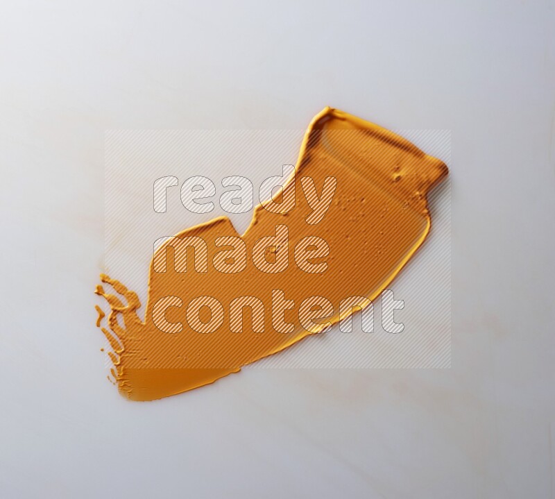 An orange single curved painting knife stroke on white background