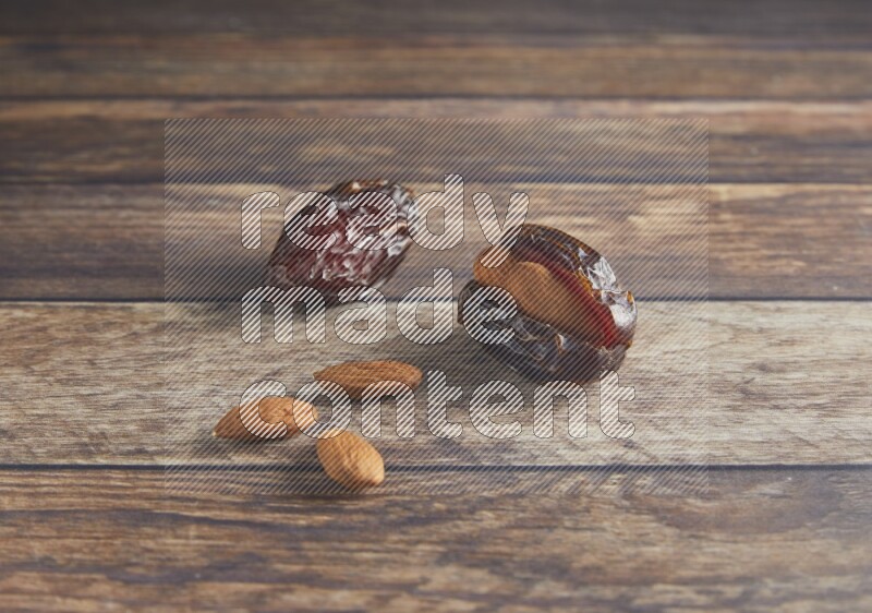 two almond stuffed madjoul dates on a wooden background