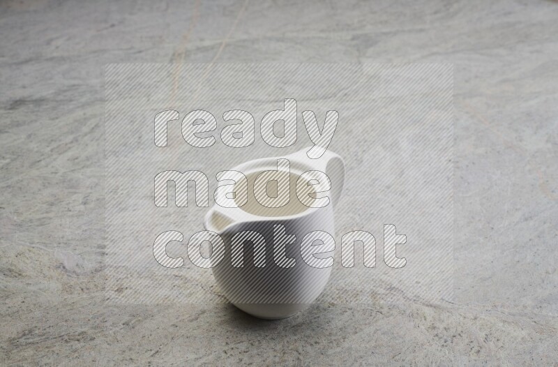 A ceramic milk jug on grey marble background
