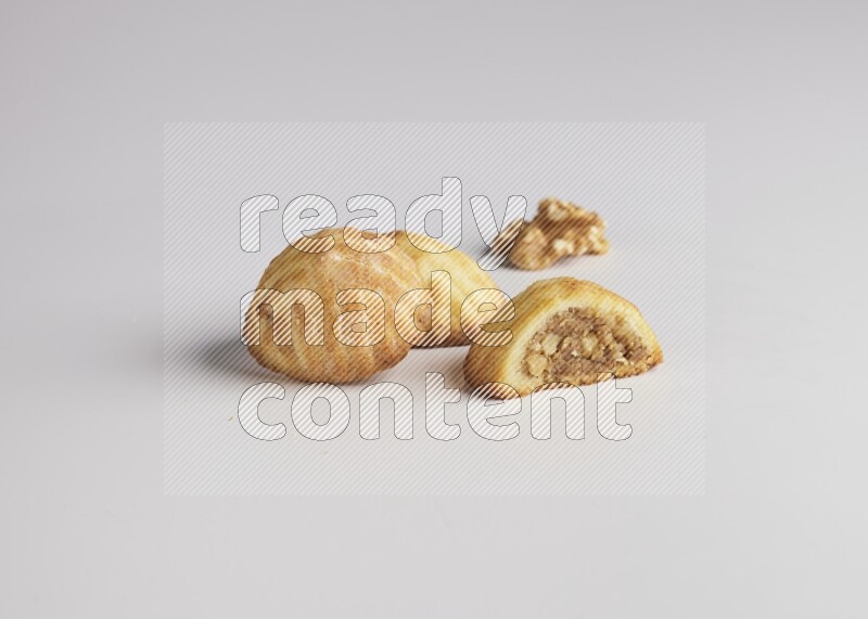 Three Pieces of Maamoul filled with walnut paste  one of them is cut direct on white background