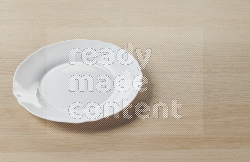 A white ceramic circular plate on light wooden background