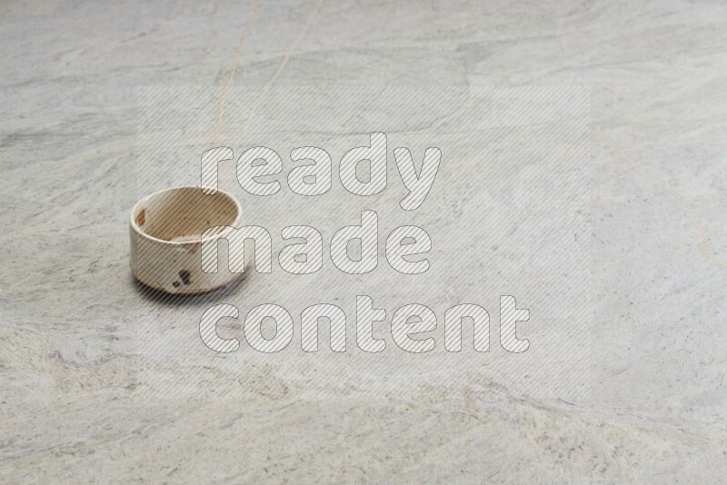 A multicolored pottery bowl on grey marble background