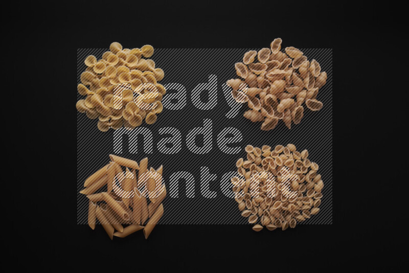 Different pasta types in bunches on black background