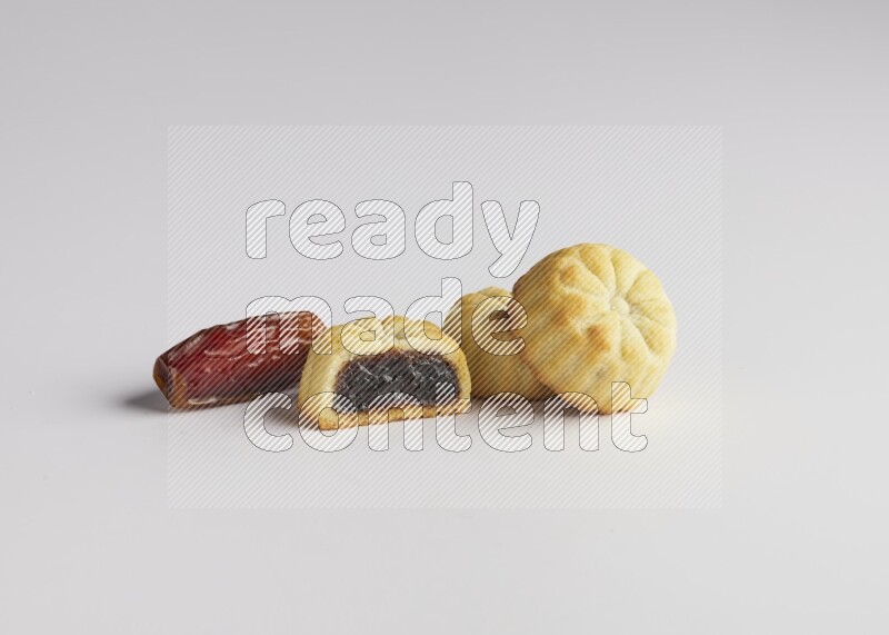 Three Pieces of Maamoul filled with date one of them is cut direct on white background