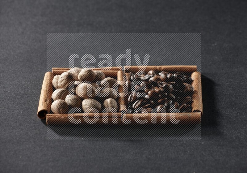 2 squares of cinnamon sticks full of coffee beans and nutmeg on black flooring