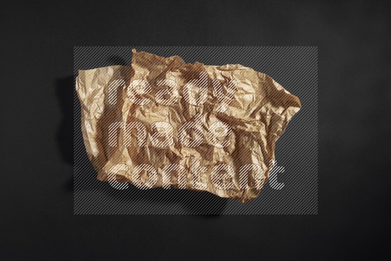 Crumpled craft paper on black background