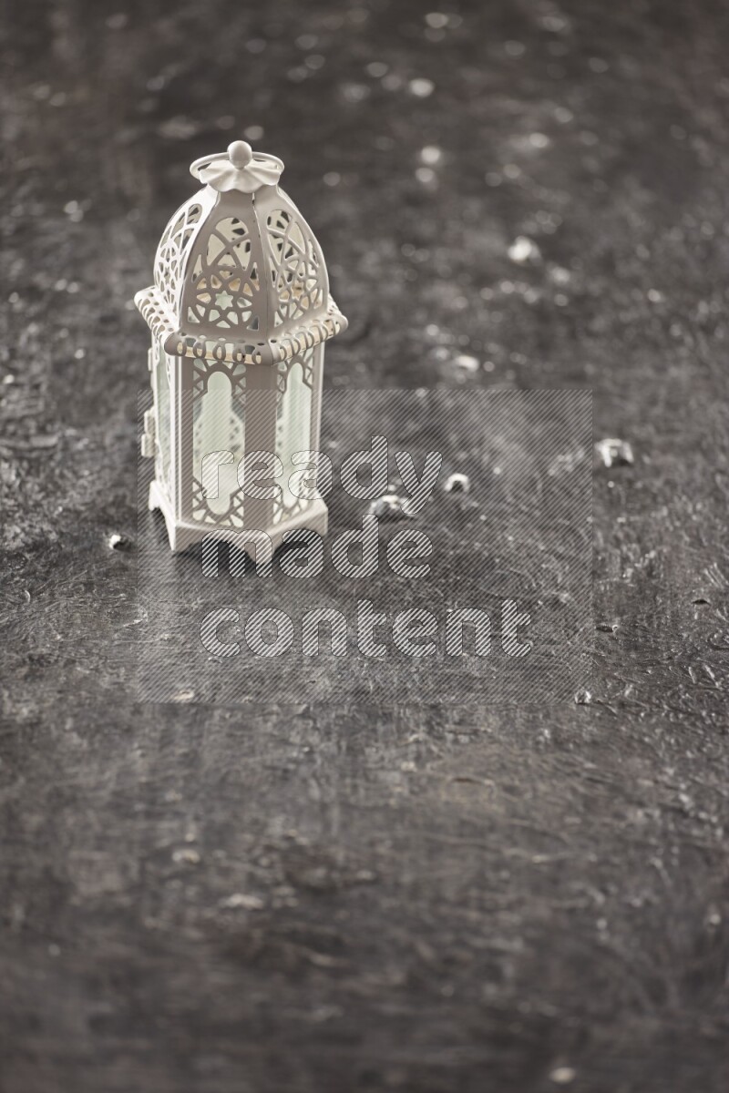 A lantern placed on a textured black background