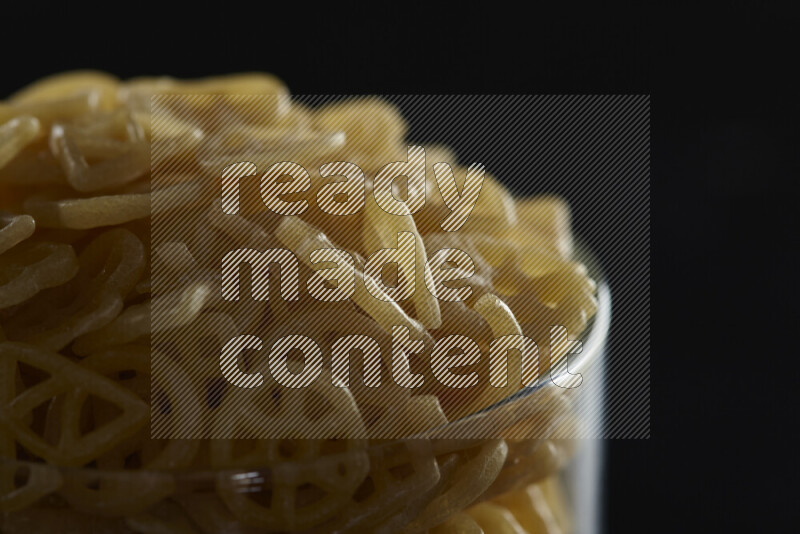 تسالي في وعاء زجاجي على خلفية سوداء