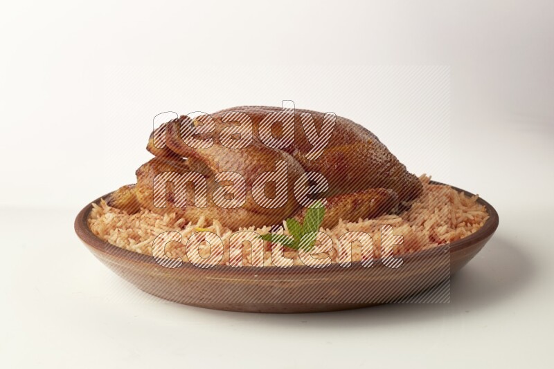 red basmati Rice with whole roasted chicken on a pottery plate direct on white background