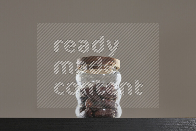 Dates in a glass jar on black background