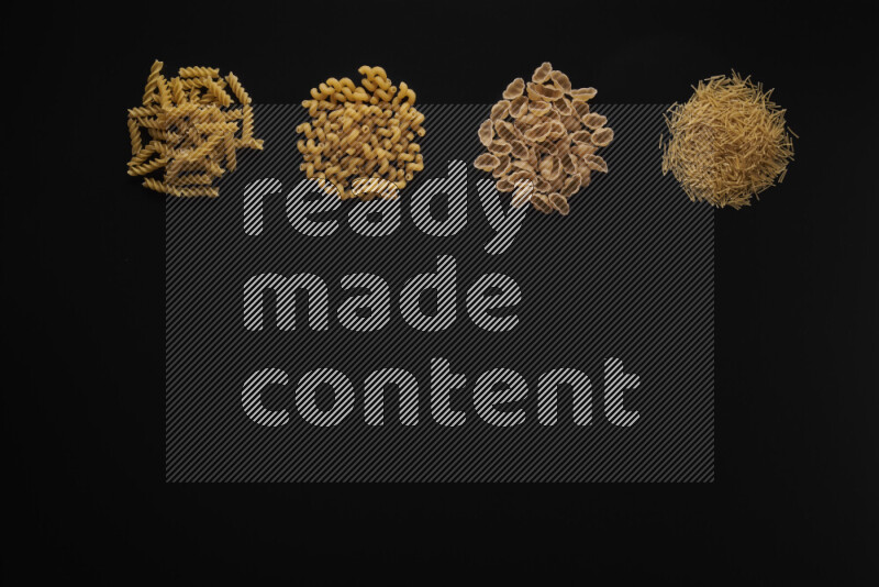 Different pasta types in 4 bunches on black background
