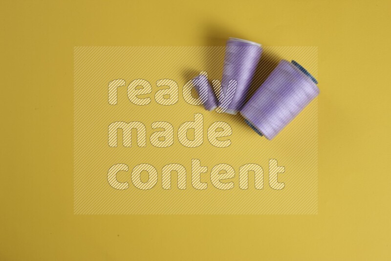 A purple collection of sewing and tailoring tools arranged on a yellow background