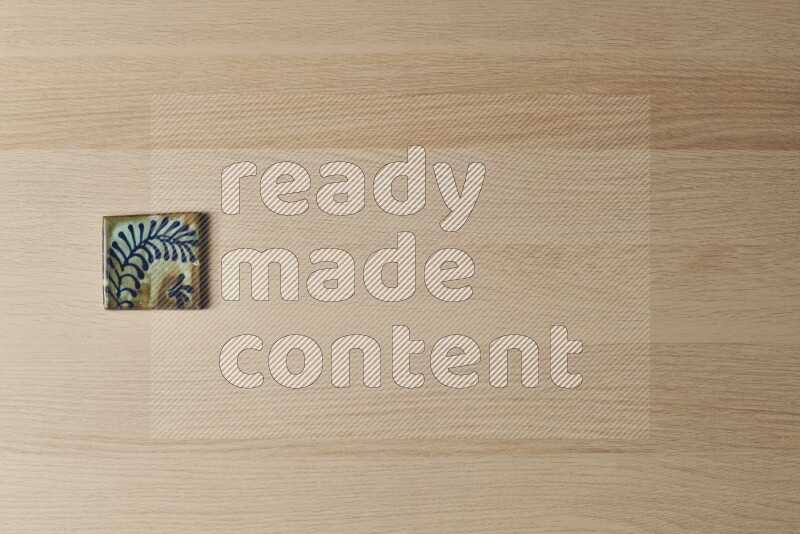 A decorative pottery coaster on light wooden background