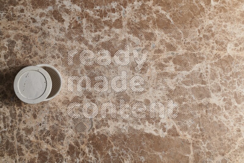A pottery cup on beige marble background