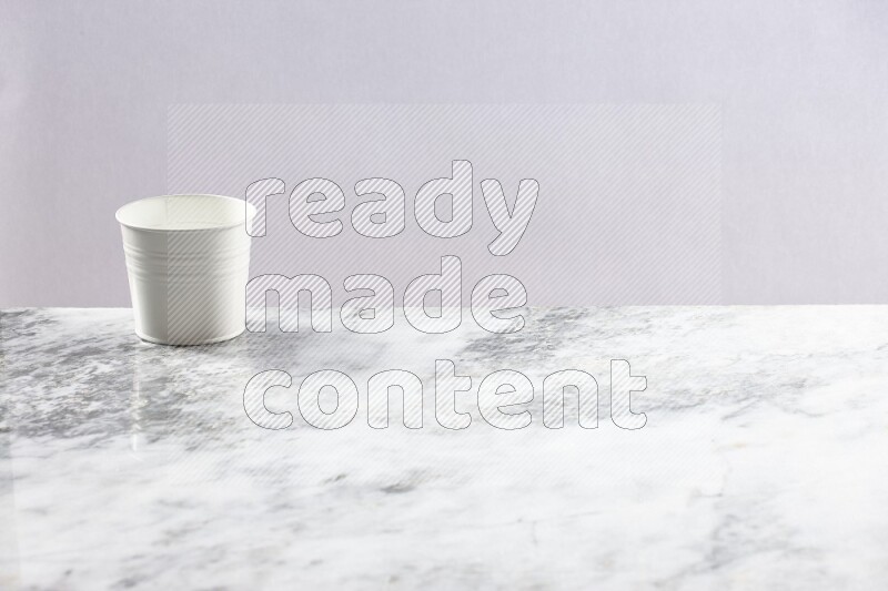 An empty white plant pot on grey marble background