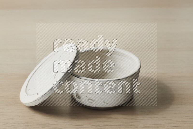 A white pottery bowl on light wooden background
