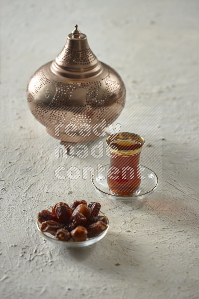 A golden lantern with different drinks, dates, nuts, prayer beads and quran on textured white background