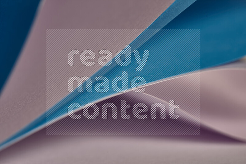 An abstract art showing purple and blue paper sheets arranged in an overlapping curves