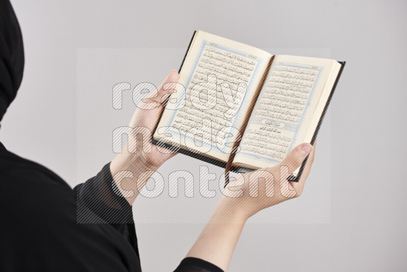 A woman hands holding moshaf in different positions