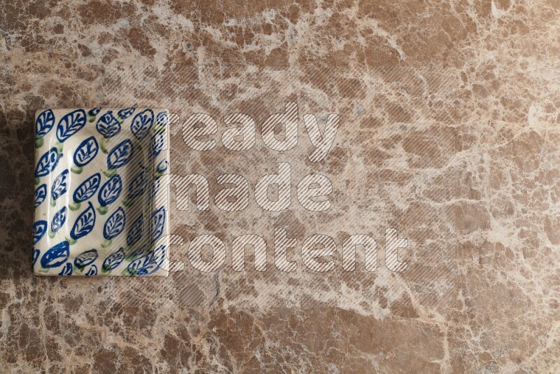 A decorative pottery plate on beige marble background