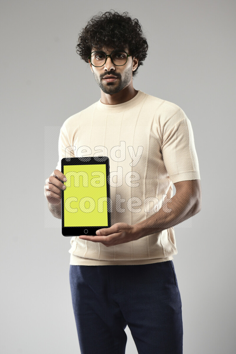 A man wearing casual standing and showing a tablet screen on white background