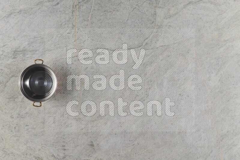 A small copper pot on grey marble background