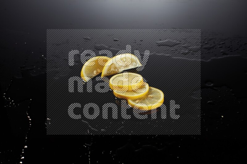 Lemon slices with water drops, and droplets on black background