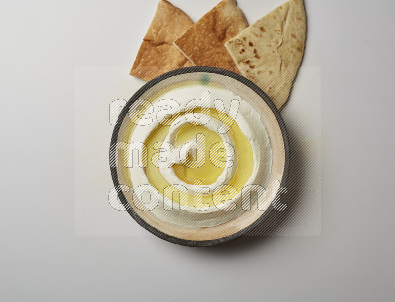 Lebnah garnished with olive oil in a pottery plate on a white background