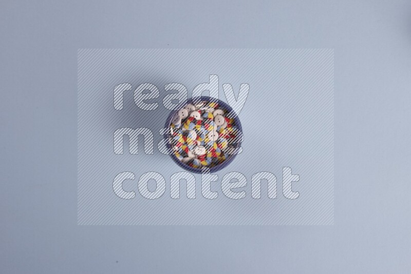 Multicolored pottery bowls full of colored buttons on blue background