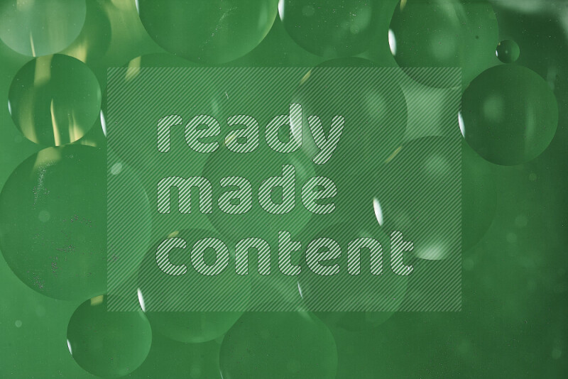 Close-ups of abstract oil bubbles on water surface in shades of green