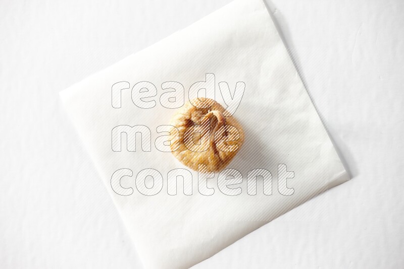 A dried fig on a piece of paper on a white background in different angles