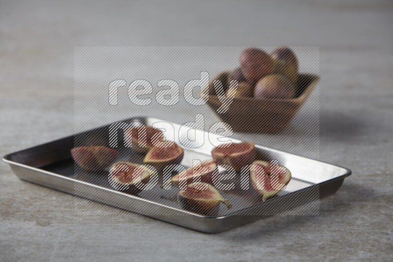 fresh figs on an oven tray on a textured grey background